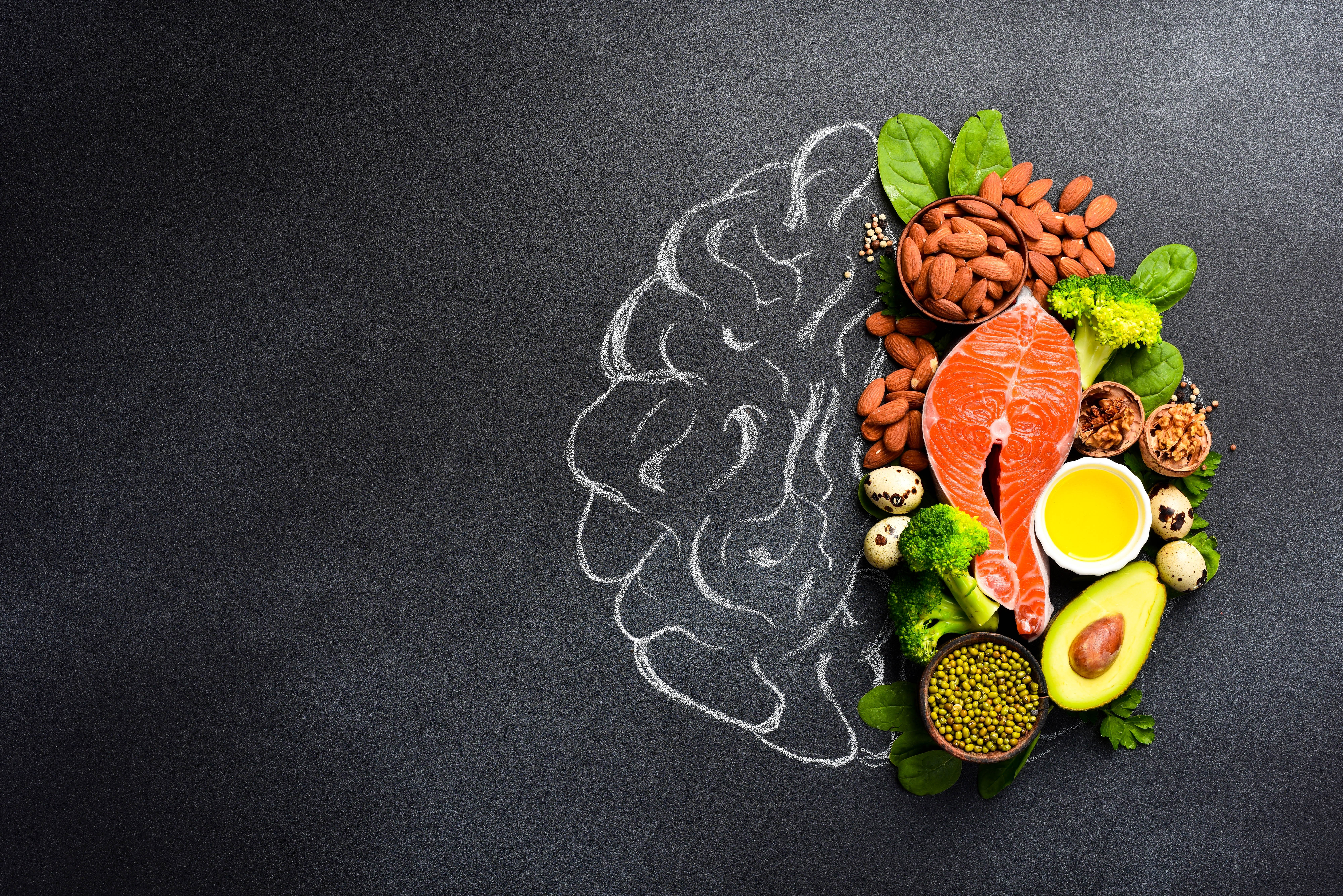 Healthy foods in the shape of a brain on a dark gray background